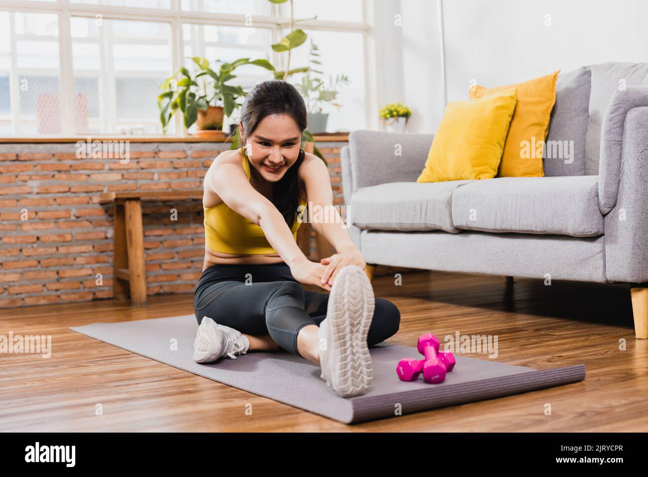 Asian beautiful woman in sport wear exercise and work out at home Stock Photo