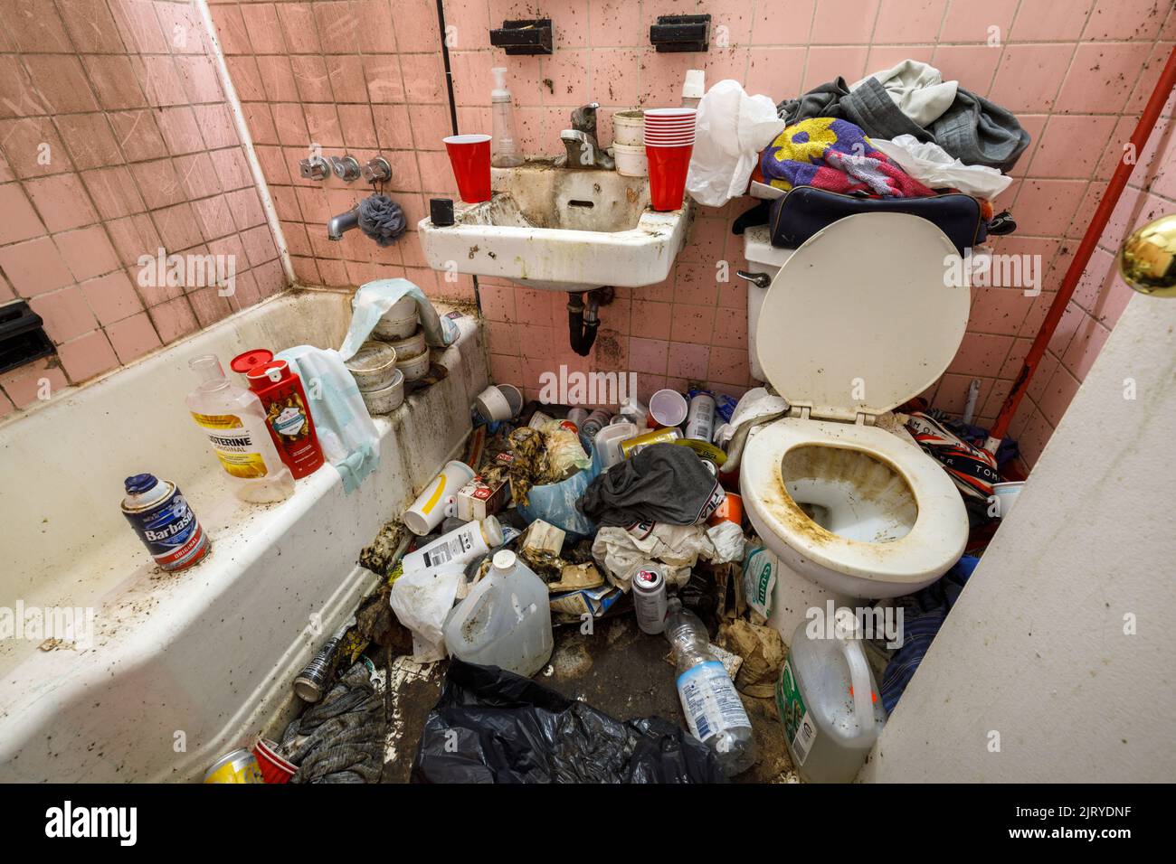 A filthy apartment bathroom with lots of clutter inside a hoarder's apartment. This building has since been demolished Stock Photo