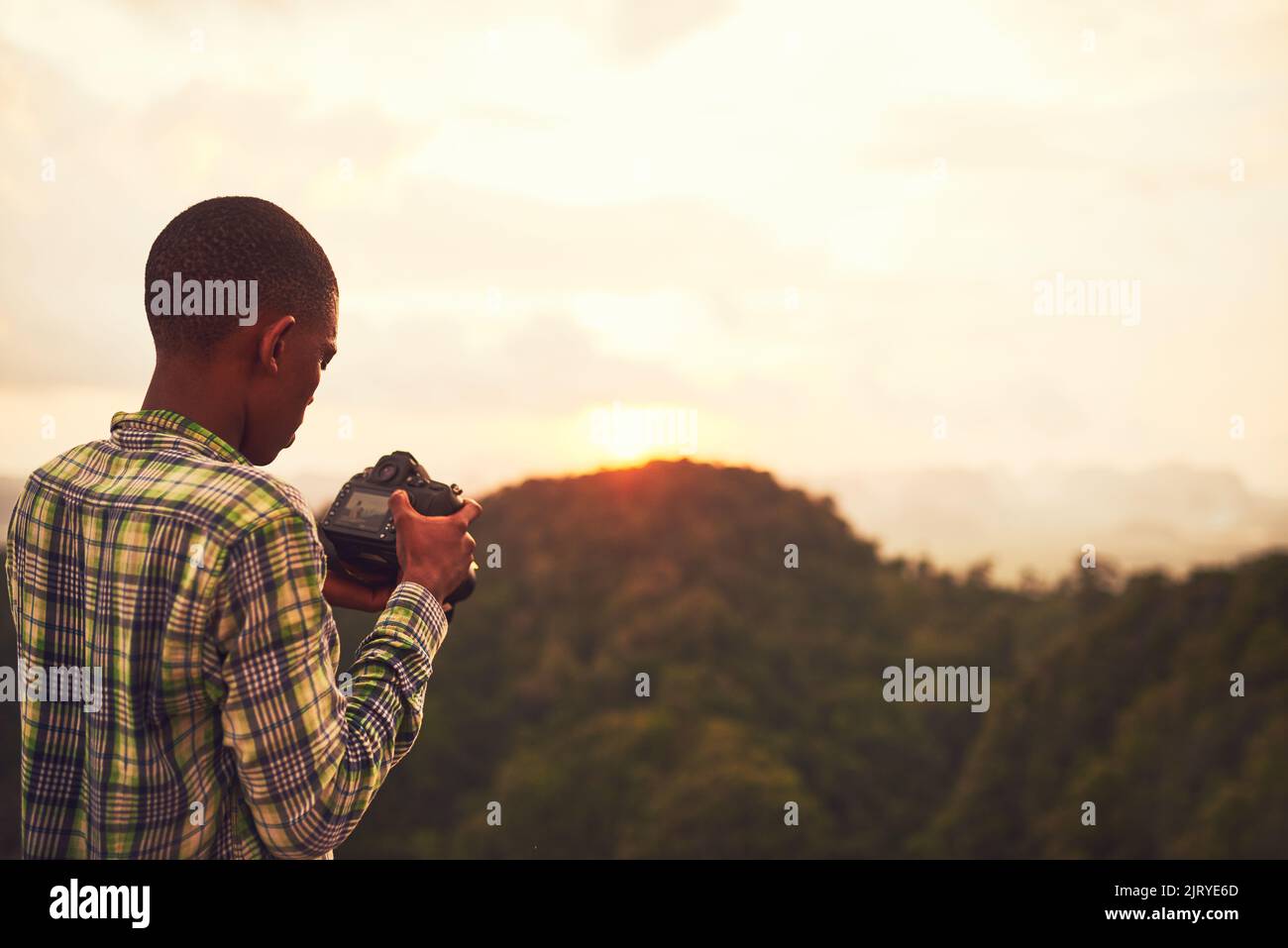 Snapping some scenic shots. a young man taking photos of a scenic view. Stock Photo