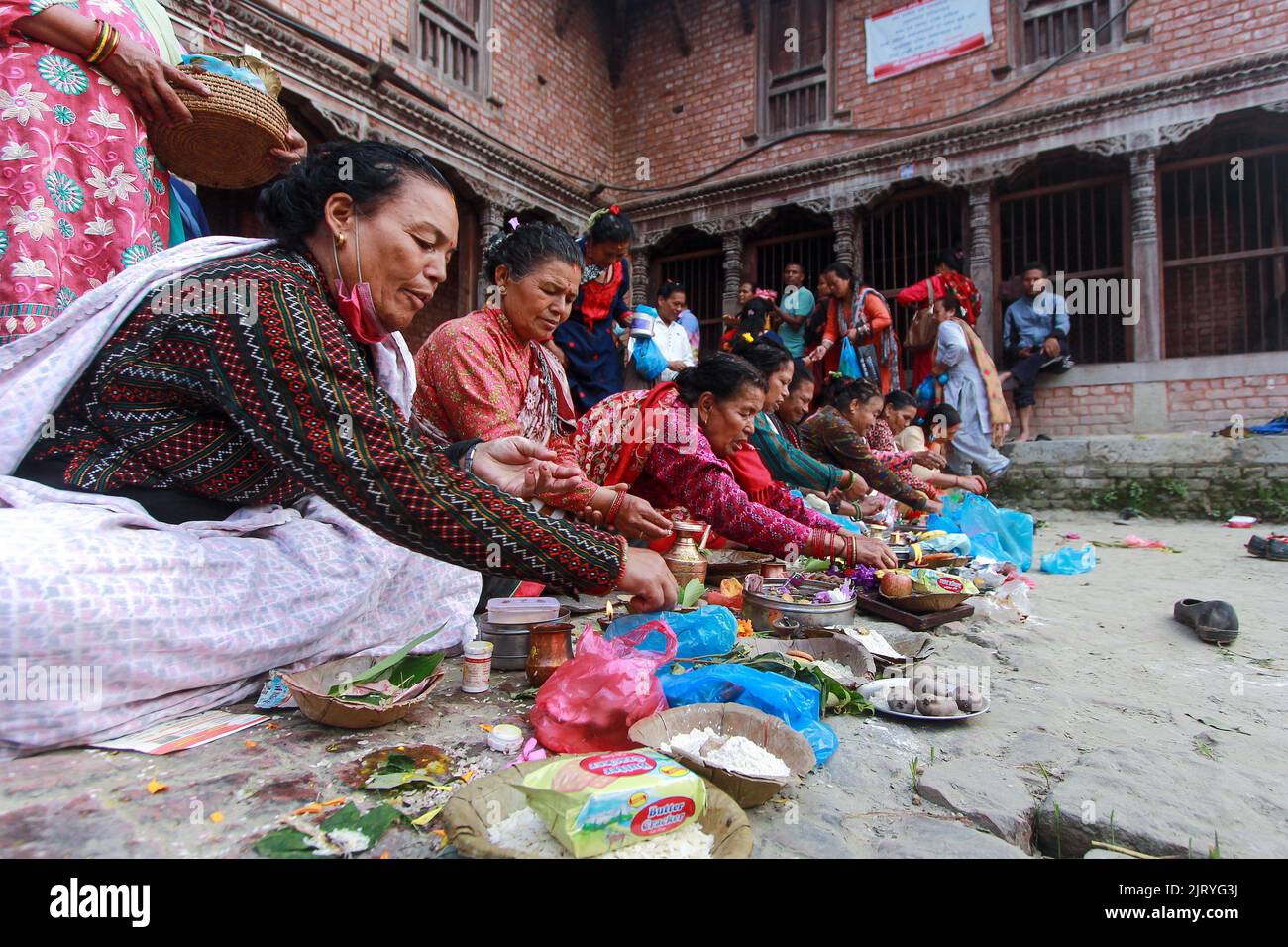 Bhaktapur, Bagmati, Nepal. 27th Aug, 2022. Group of women performing traditional ritual on the occasion of ''˜Kushe Aunsi', the traditional father's day at the bank of Hanumante River at Bhaktapur on Saturday.The festival is celebrated by remembering and paying respect to father for his care and love to family members. People who have lost their father remembers them by going to temples, conducting Shraddha and offering sida (sida is a holy mixture of grains) to priests. (Credit Image: © Amit Machamasi/ZUMA Press Wire) Credit: ZUMA Press, Inc./Alamy Live News Stock Photo