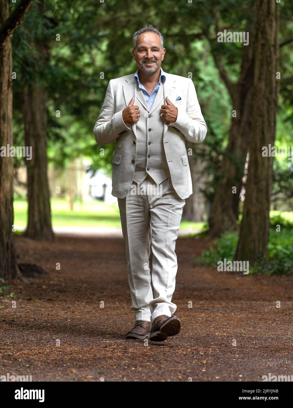 Middle-aged man walking through park in suit, Karlsruhe, Germany Stock Photo