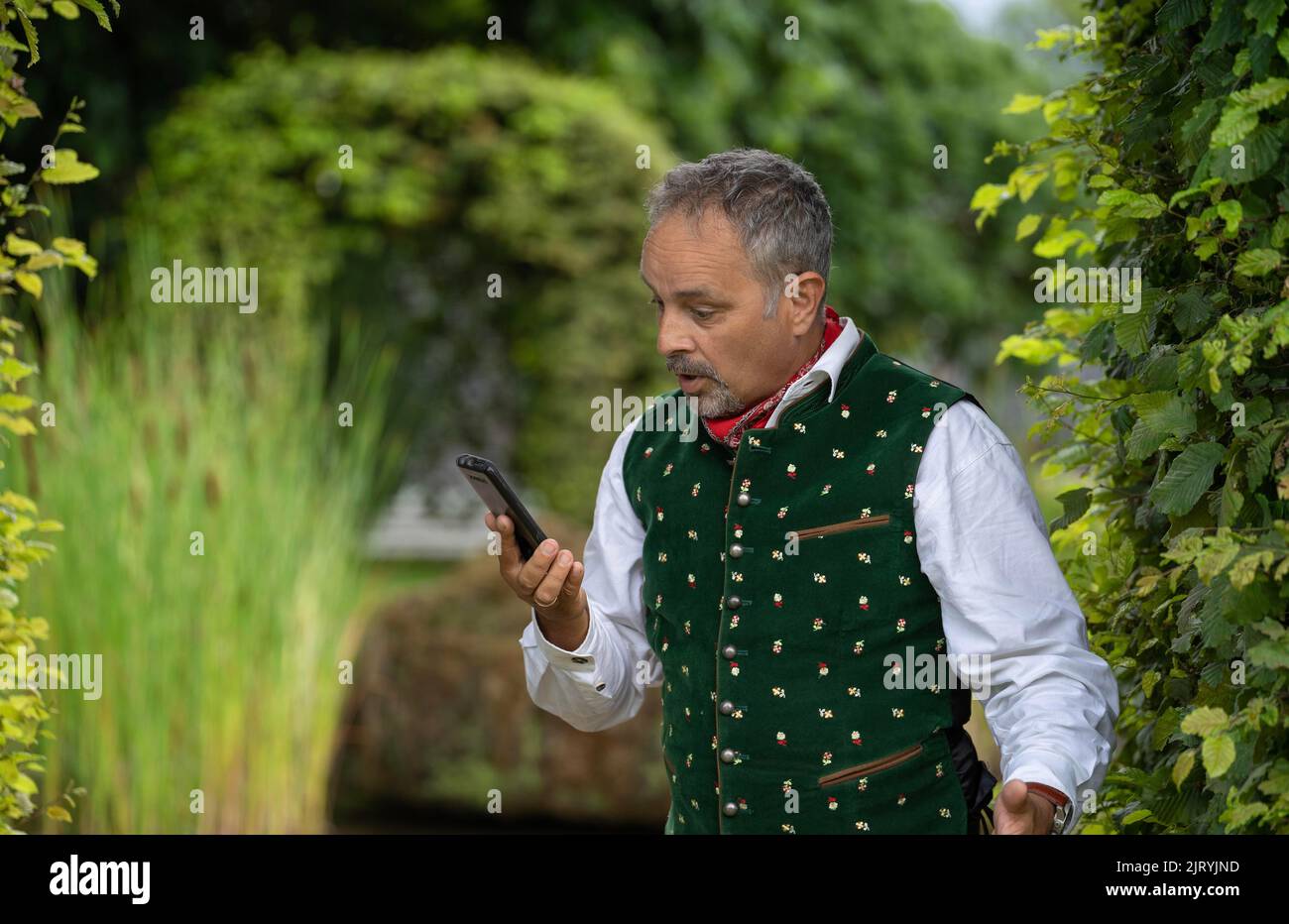 Middle-aged man looking confused at his phone, Karlsruhe, Germany Stock Photo