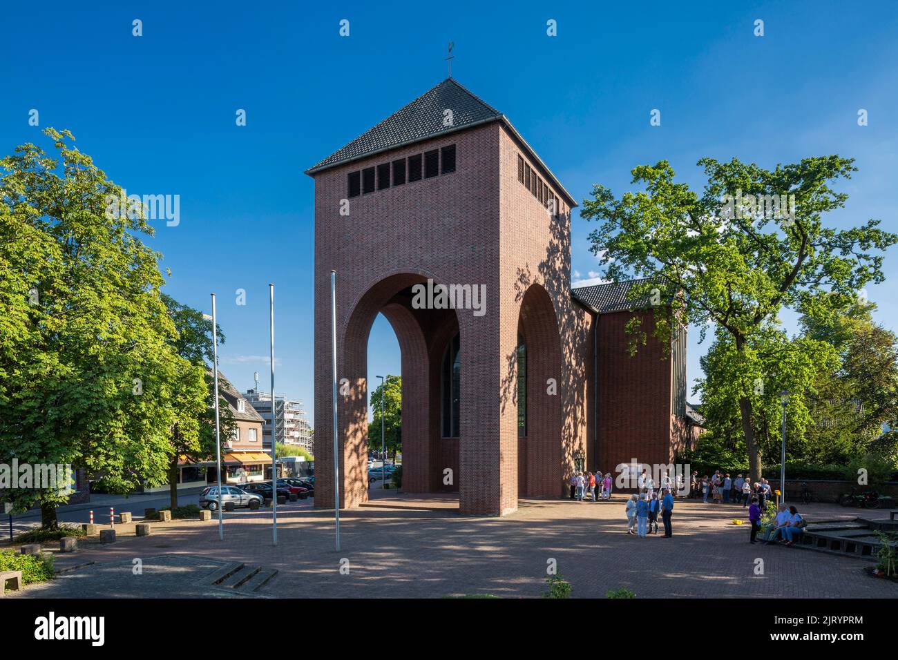 Germany, Bocholt, Lower Rhine, Westmuensterland, Muensterland, Westphalia, North Rhine-Westphalia, NRW, Catholic Church Holy Cross by Dominikus Boehm, basilica with stilts tower, brick building, people on the courtyard wait for the liturgy Stock Photo