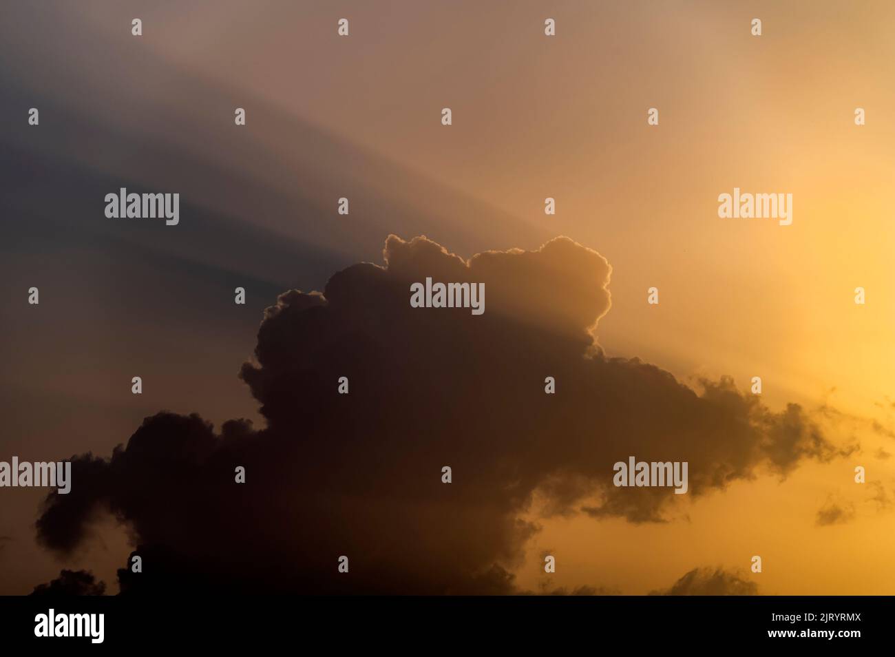 dramatic clouds with light beams, sun rays with clouds in the blue sky Stock Photo