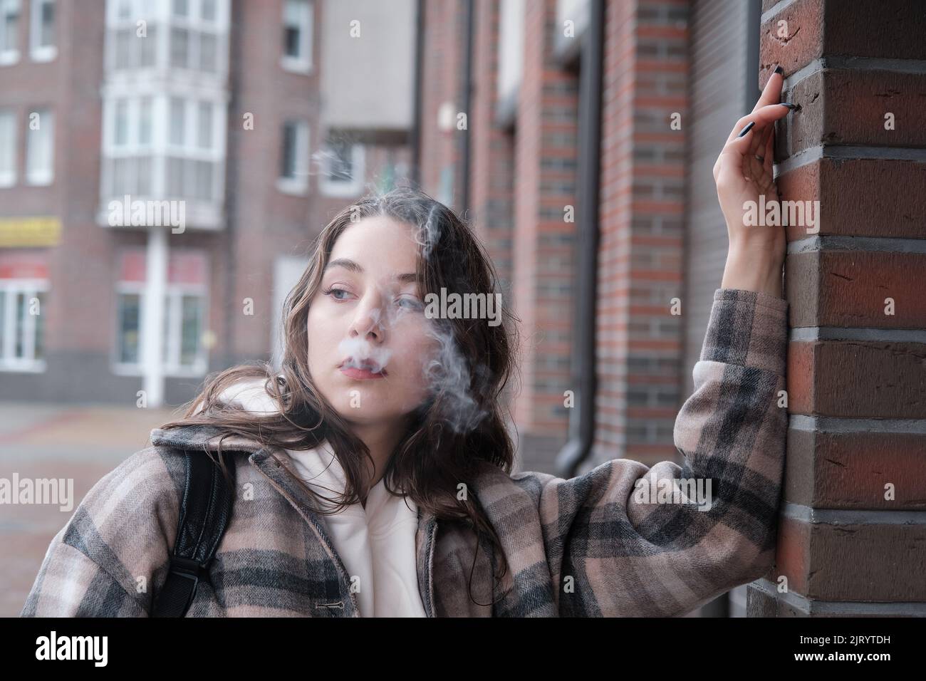young woman on city street exhale smoke closeup portrait Stock Photo