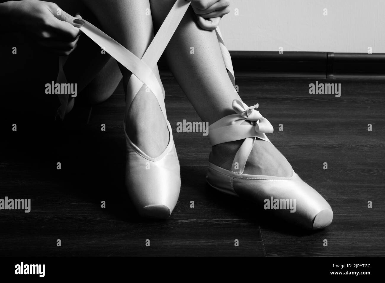 female ballerina feet with pointes on a wooden floor closeup image