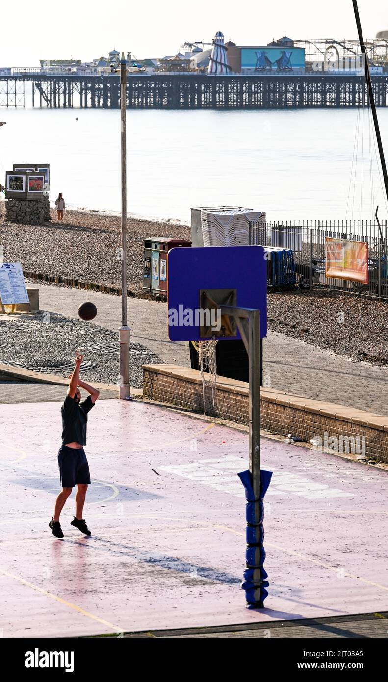 Brighton UK 27th August 2022 - A basketball player enjoys the early morning sunshine on Brighton seafront as more good weather is forecast for the bank holiday weekend in the UK . : Credit Simon Dack / Alamy Live News Stock Photo