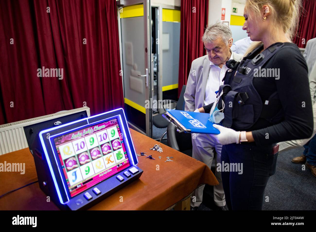 Duisburg, Germany. 26th Aug, 2022. A policewoman checks illegal gambling machines during a raid in the north of Duisburg with the Interior Minister of North Rhine-Westphalia Herbert Reul (CDU)on Friday evening. Task forces from various authorities searched 13 properties in the city area in a joint operation against clan crime and checked more than 130 people, according to a press release. Credit: Christoph Reichwein/dpa/Alamy Live News Stock Photo