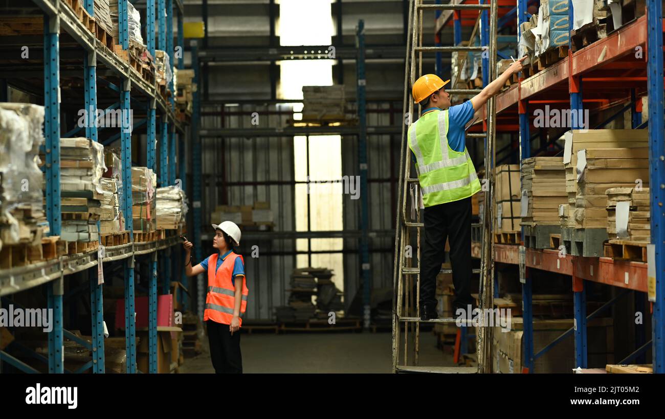 Storehouse employees wearing hard hats and reflective jackets taking