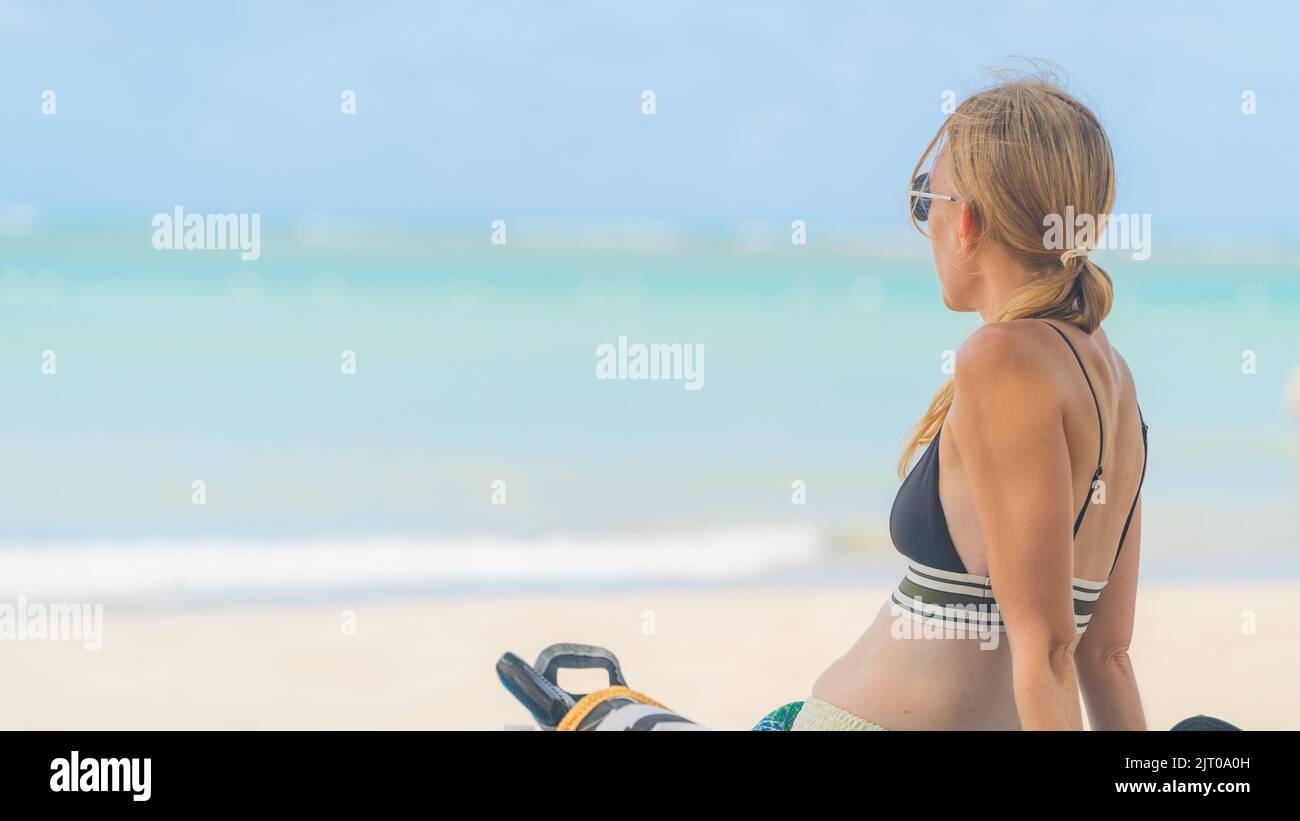 blonde woman relaxing on tropical beach with sunglasses in bikini Stock Photo