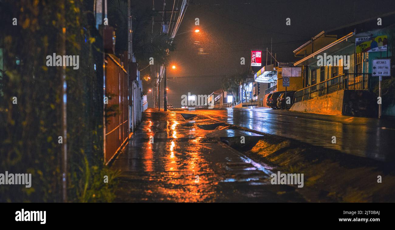 A dramatic rainy night with illuminated street lamps in Atenas city Stock Photo