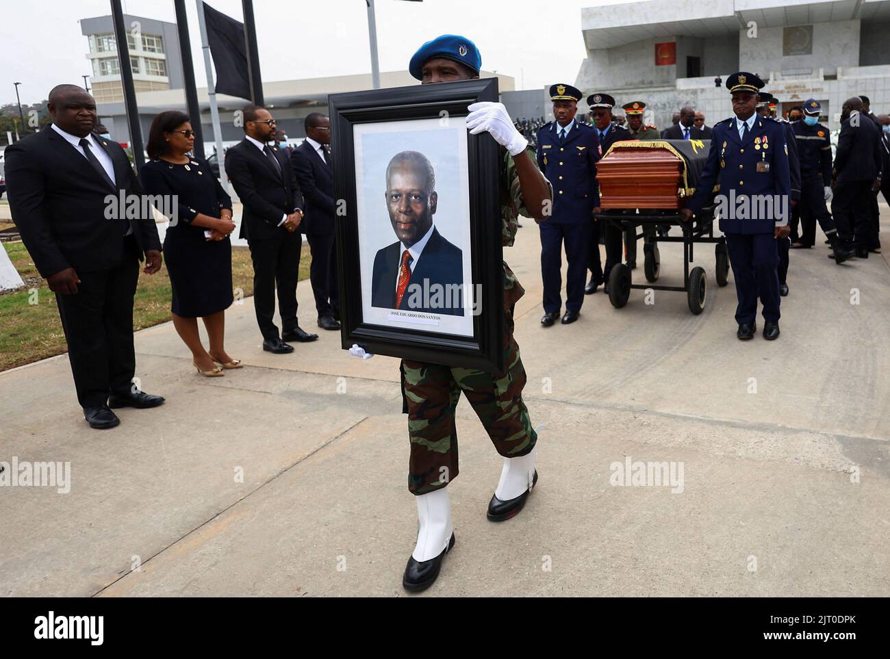 A member of the military holds a portrait as a casket carrying the body of Angola's former President Jose Eduardo dos Santos, who died in Spain in July, arrives at the Agostinho Neto Memorial in Luanda, August 27, 2022. REUTERS/Siphiwe Sibeko Stock Photo