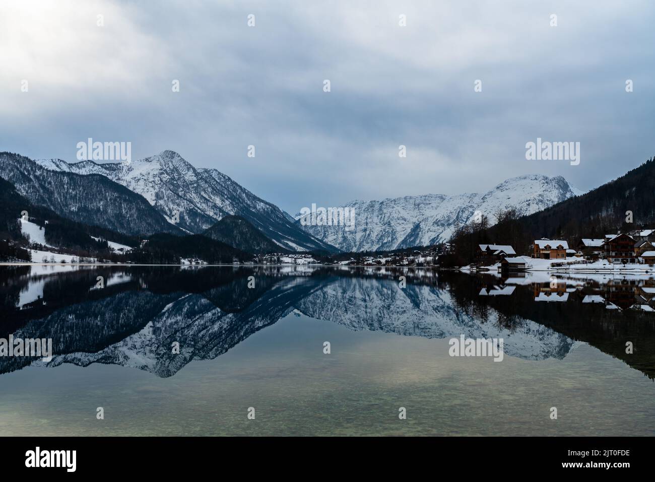 Stunning panorama view of Grundlsee lake with snow covered mountain peaks of Styrian Alps in background on a sunny winter day, Ausseerland - Salzkamme Stock Photo