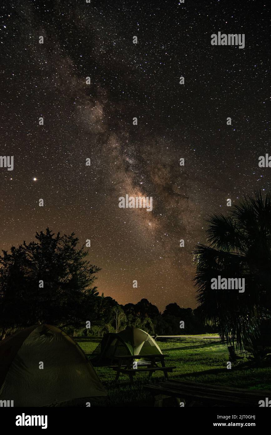 A vertical shot of the milky way in the starry sky at a camping area in ...