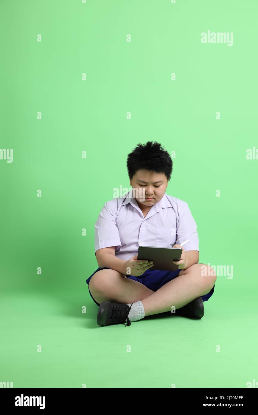 The Asian boy with student uniform on the green background Stock Photo ...