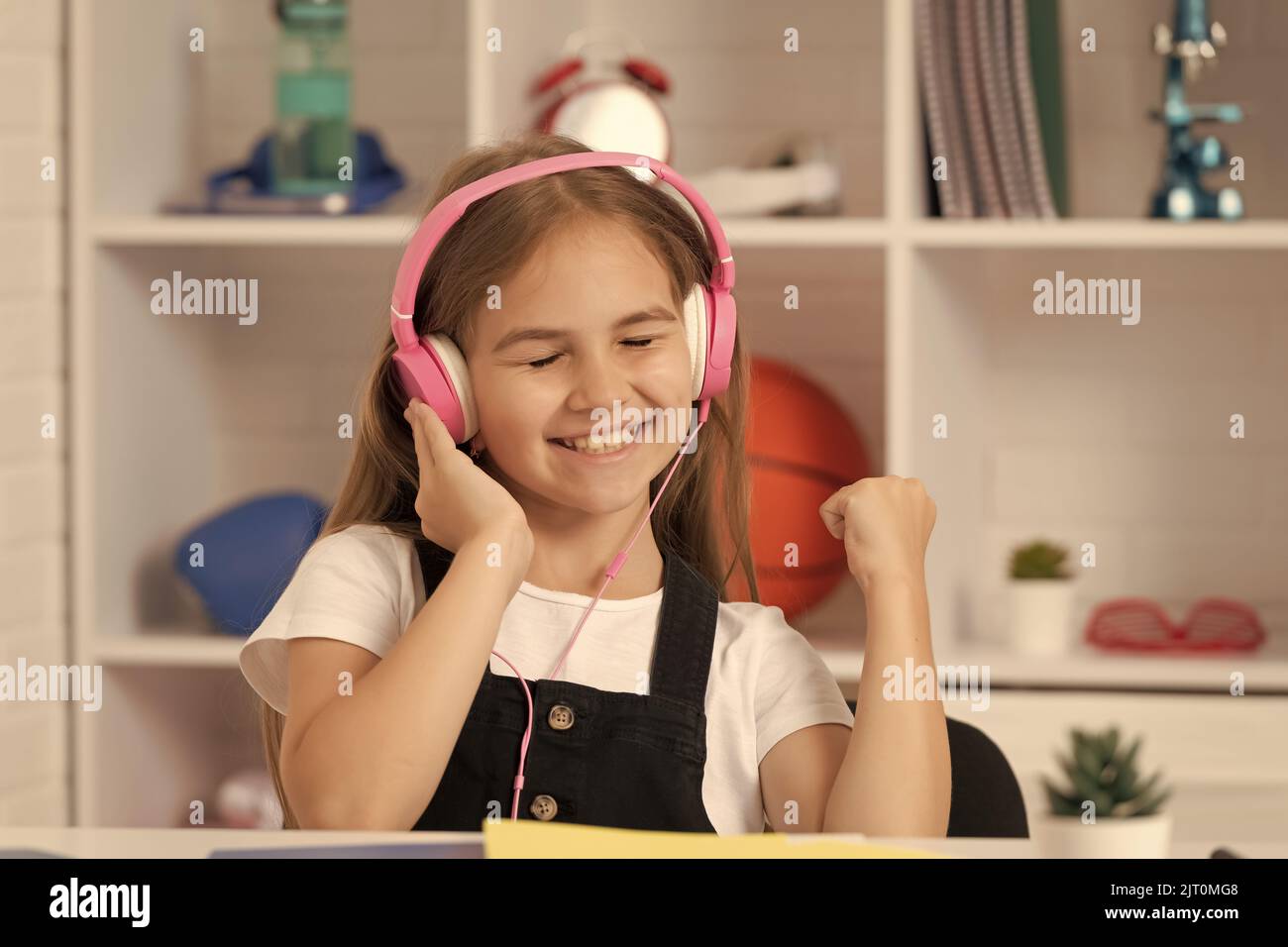 happy kid listen to music in headphones at school classroom Stock Photo