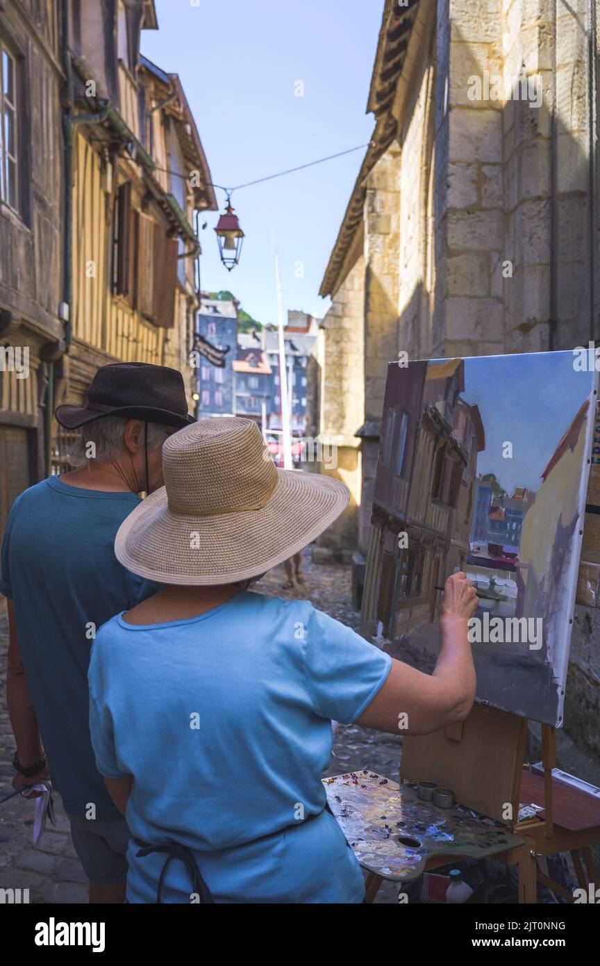Normandy, a street painter in the old harbor basin. Honfleur, France - August 2022  Stock Photo