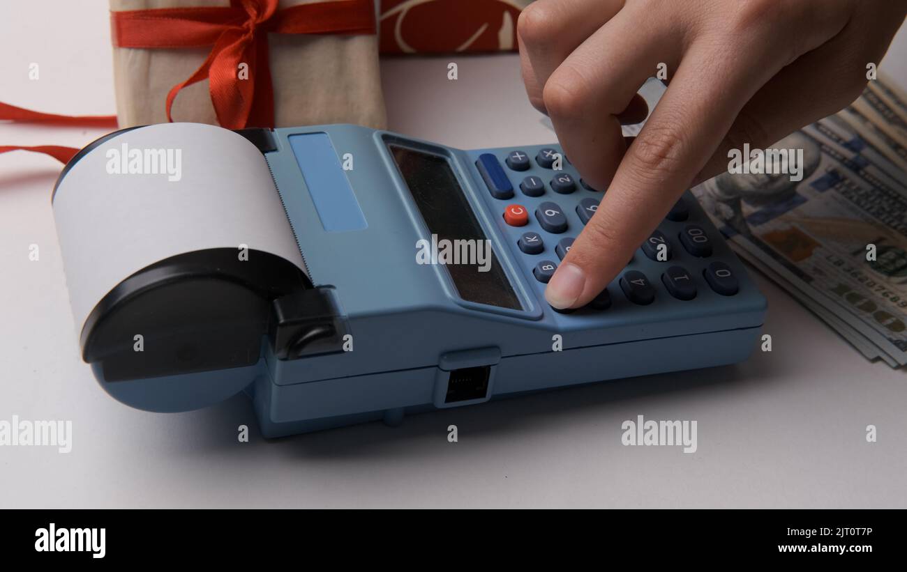 The seller enters the amount into the cash register in the retail store, prints the receipt. A woman's hand presses the pos terminal button. Business Stock Photo