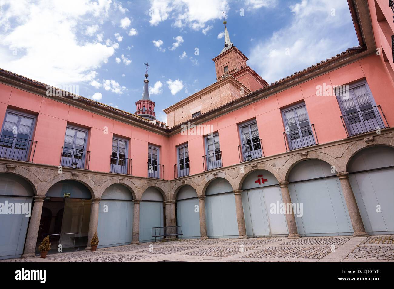 Alcalá de Henares, Spain - June 18, 2022: Internal courtyard of the Cervantes Institute of Alcalà de Henares and in the background the bell towers of Stock Photo