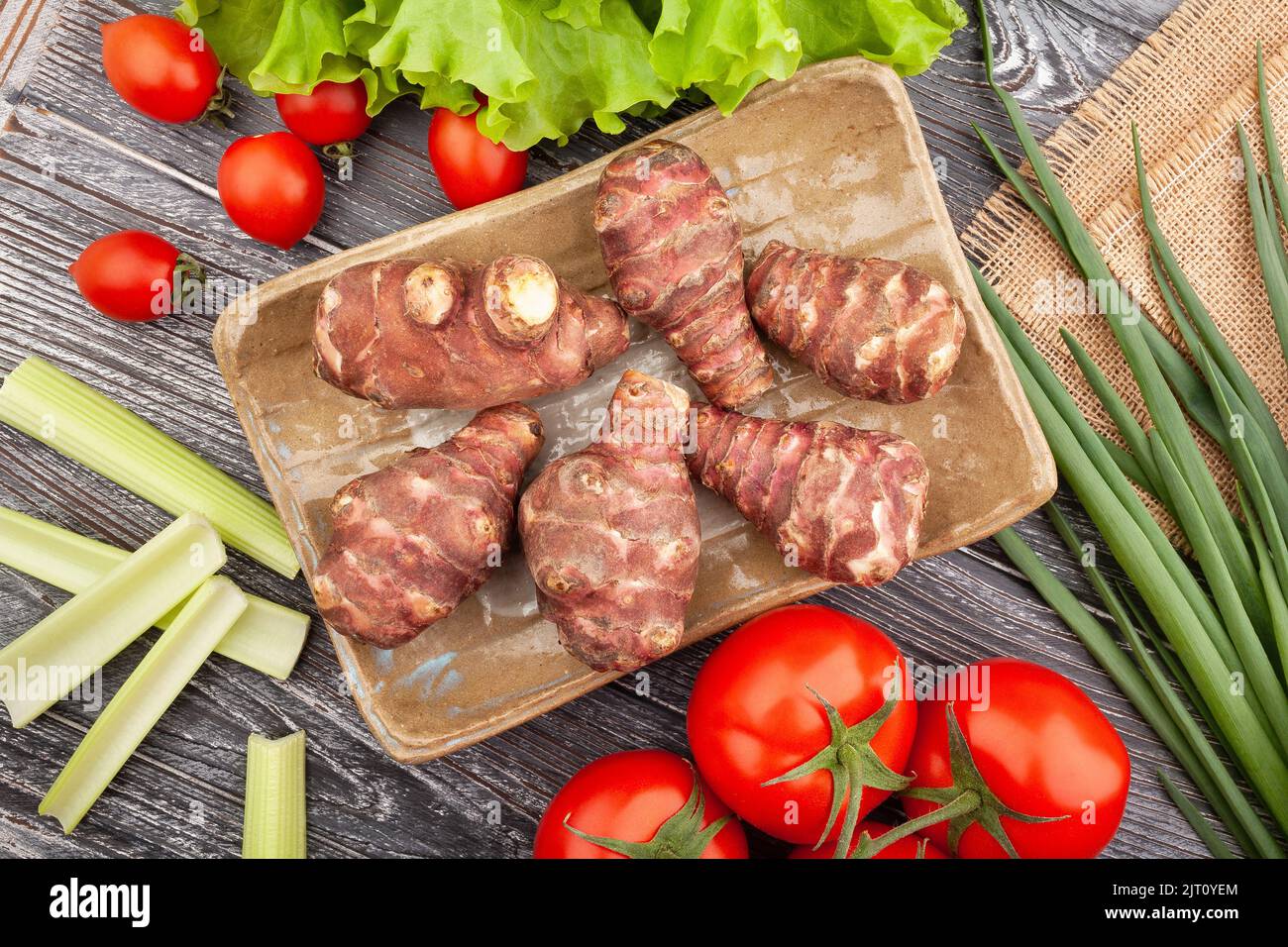topinambur on a plate on wood background Stock Photo