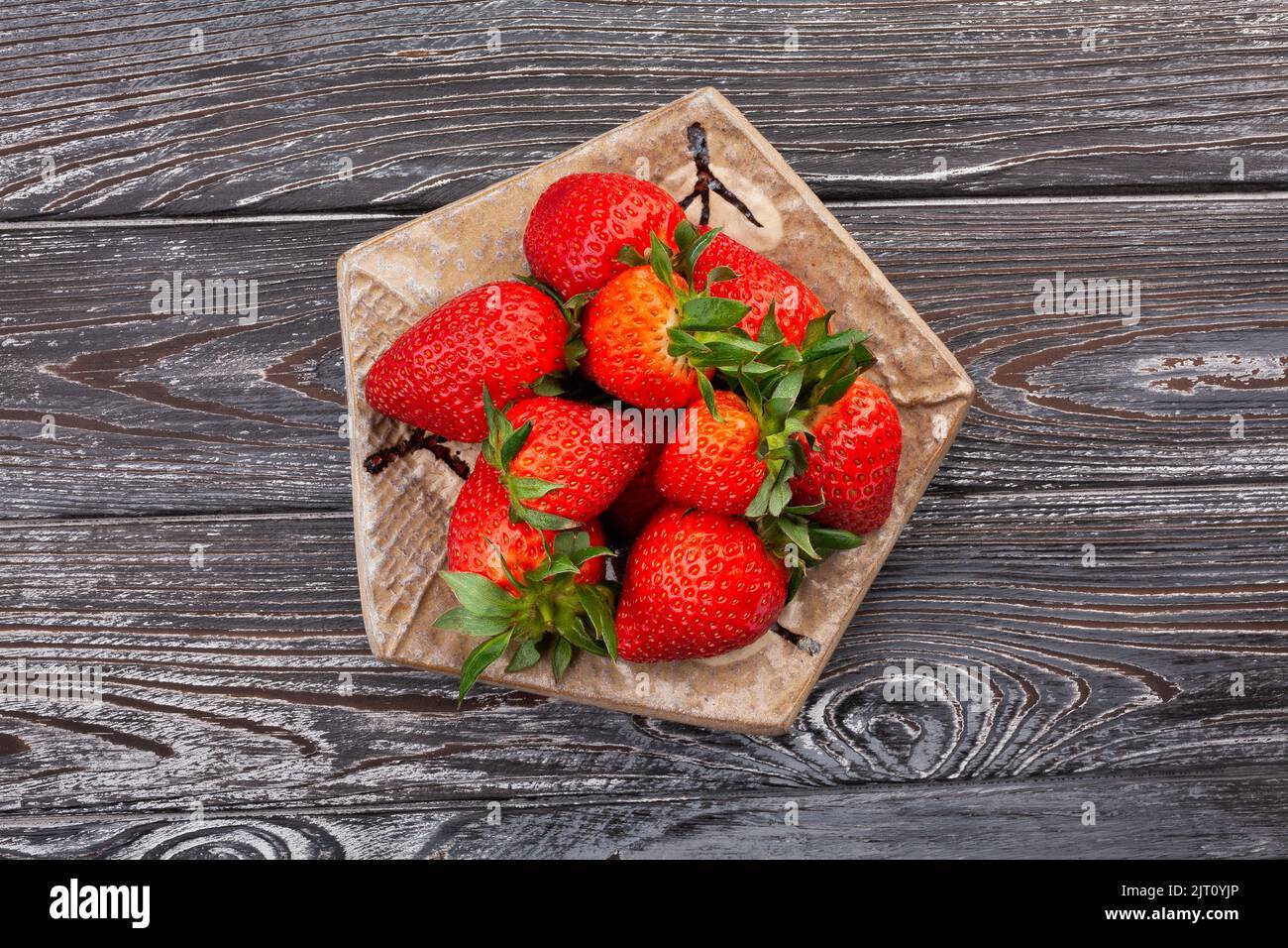strawberry on a plate on wood background Stock Photo