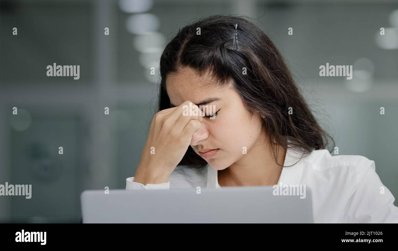 Closeup young sad tired woman manager looking at laptop screen in