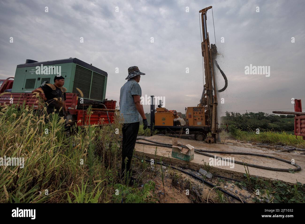 Head of a drilling crew Gao Pucha watches as his drill hits water as the region experiences a drought outside Jiujiang city, Jiangxi province, China, August 27, 2022.  REUTERS/Thomas Peter Stock Photo