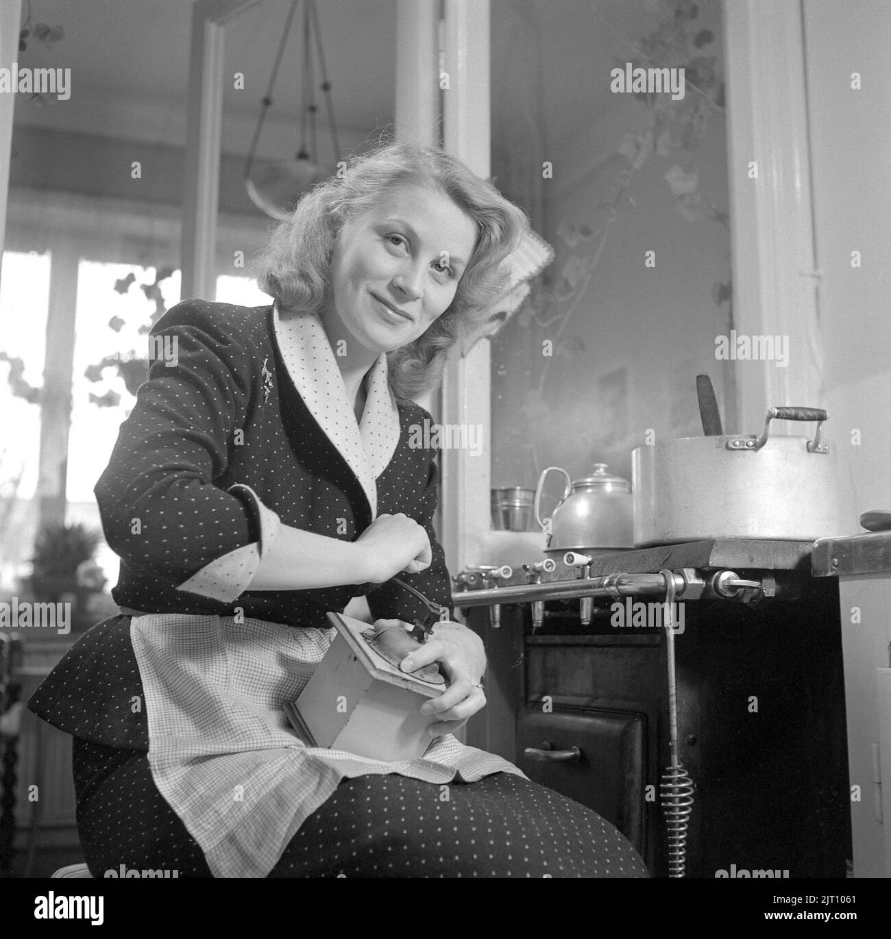 Grinding coffee in the 1950s. Actress Ulla Holmberg 1924-2008 grinding coffee in the kitchen. Sweden 1951 ref 1685 Stock Photo
