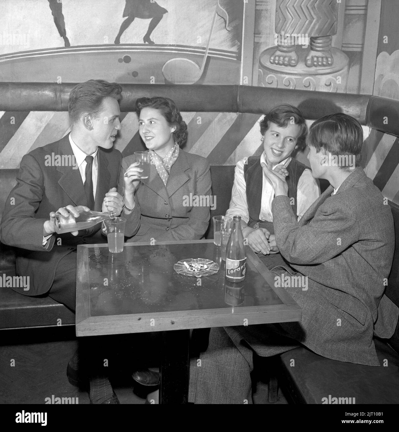 In the 1950s. Two young couples in the bar at Nalen dance establishment in Stockholm that at the time did not allow alcoholic beverages. Smoking however is ok. Sweden 1951 Conard ref 1871 Stock Photo