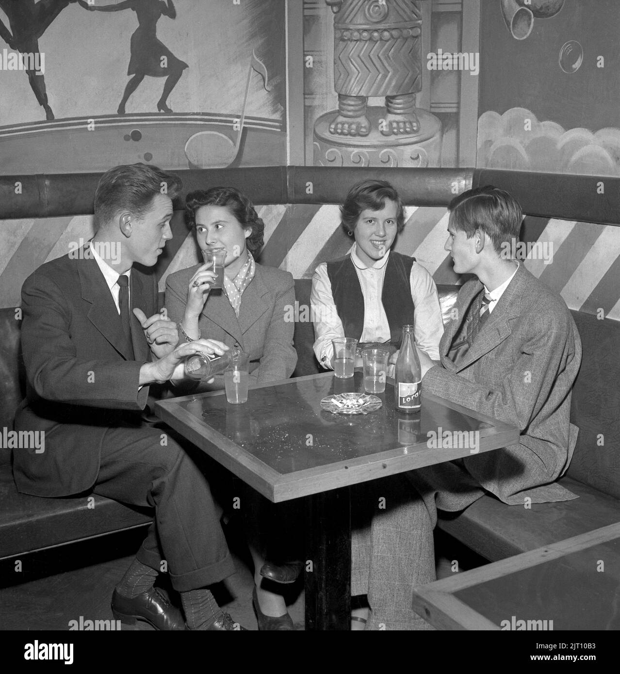 In the 1950s. Two young couples in the bar at Nalen dance establishment in Stockholm that at the time did not allow alcoholic beverages. Smoking however is ok. Sweden 1951 Conard ref 1871 Stock Photo