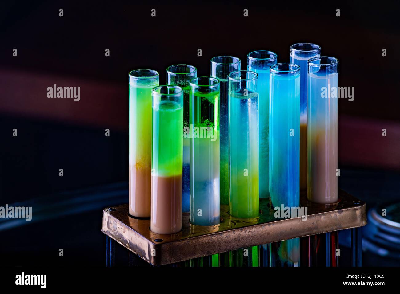 Colorful shot drinks in glass tubes. Dark background, atmospheric bar