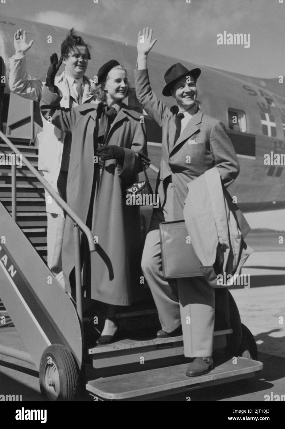 1940s vacation. Three people are standing on the stairs leading on the airplane, waving goodbye to someone. The are Ake Ohberg, Margareta Fahlen and Sten Dahlgren on way to be part in the movie Vi flyger på Rio 1949. Stock Photo