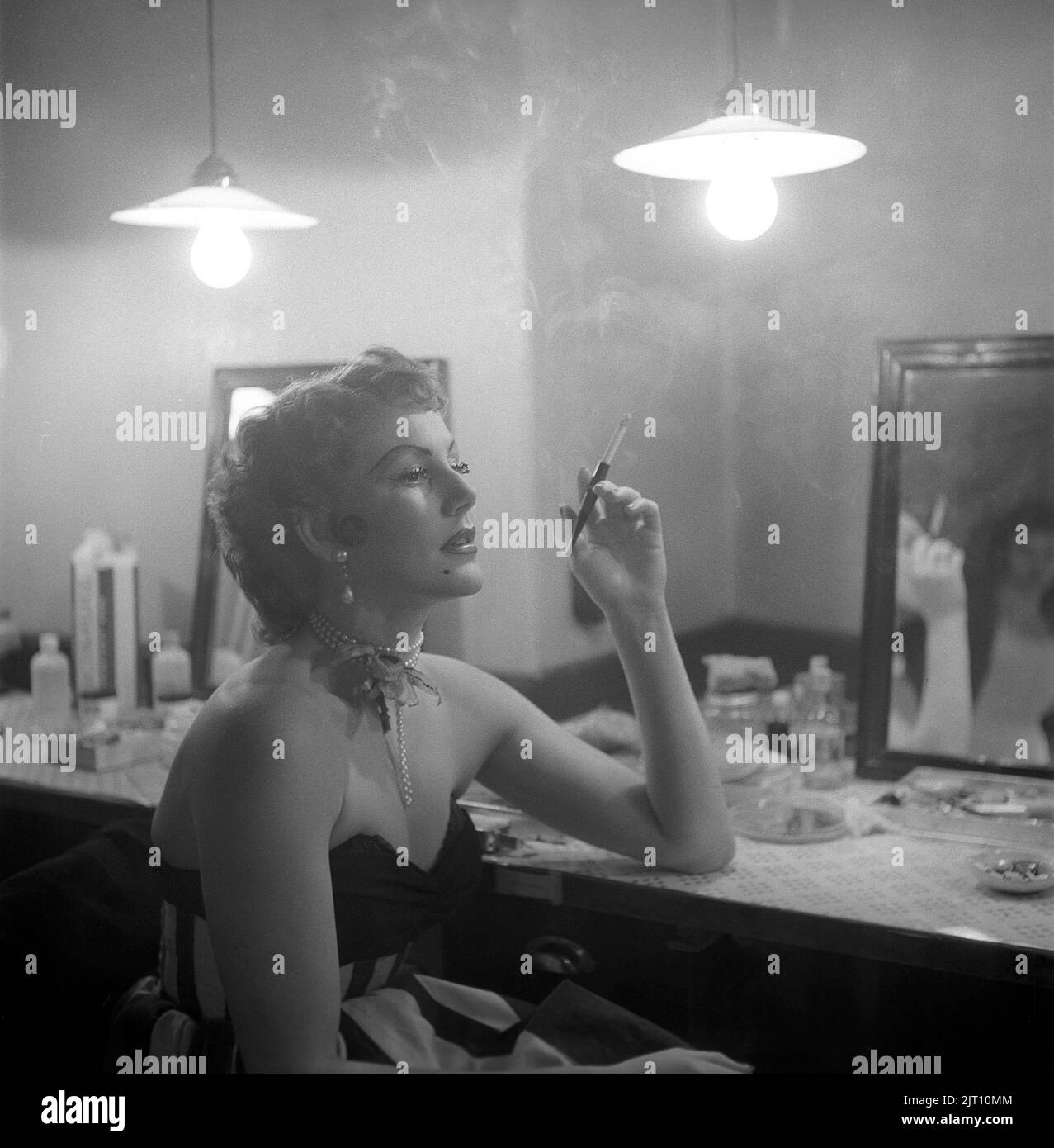 Karin Maria Elisabet Mathisen, known as Topsy Hakansson, born january 12 1926. Swedish dancer and actress pictures in her dressing room behind the theatre stage while having a cigarette. She uses a cigarette holder and that makes the picture elegant. Sweden 1952 Kristoffersson ref BH99-7 Stock Photo