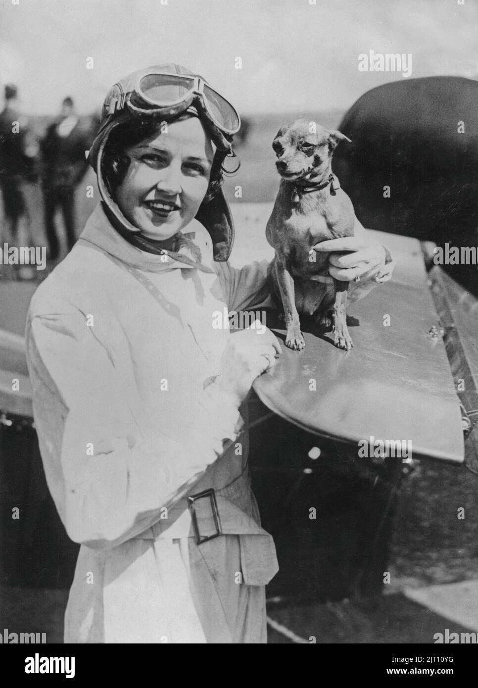 Rosalie Gordon. American pilot in Gates Flying Cirucs that in the 1920s became exceedingly popular and drew around 30 000 spectators to every show. She was one of the Gates Flying Circus main attractions as the first female skydiver. Pictured here beside her airplane with her dog. 1930s. Stock Photo