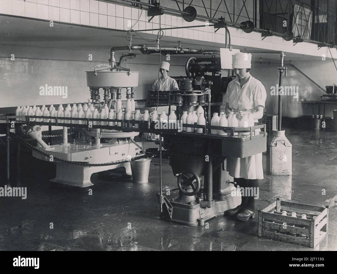 Dairy in the 1930s. An interior of Mjolkcentralen and it's filling station of milk bottles. An early semi-automated production line where empty bottles were filled and capped. The distribution of milk in glass bottles was disused in the 1950s in Sweden. Stock Photo
