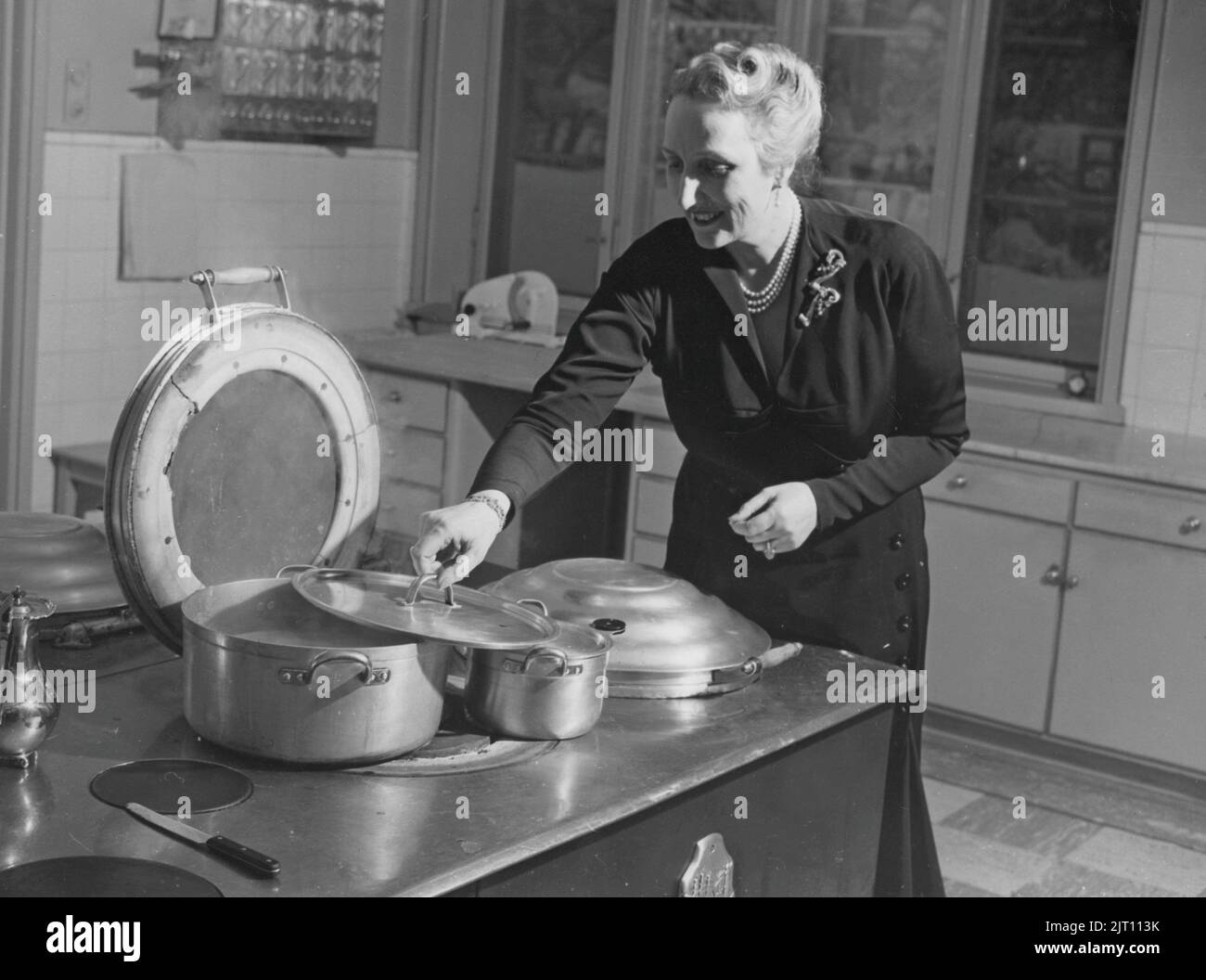 Crown Princess Martha of Norway. 1901-1954. Daughter of swedish Prince Carl. Pictured here in the 1951 in the kitchen with a AGA cooker visible. A swedish invention by Gustaf Dalén with the principle of heat storage, a combination of two large hotplates and two ovens into one unit, the AGA cooker. The oldest AGA cooker still in use belongs to the Hett family of Sussex and it was installed 1932. Stock Photo