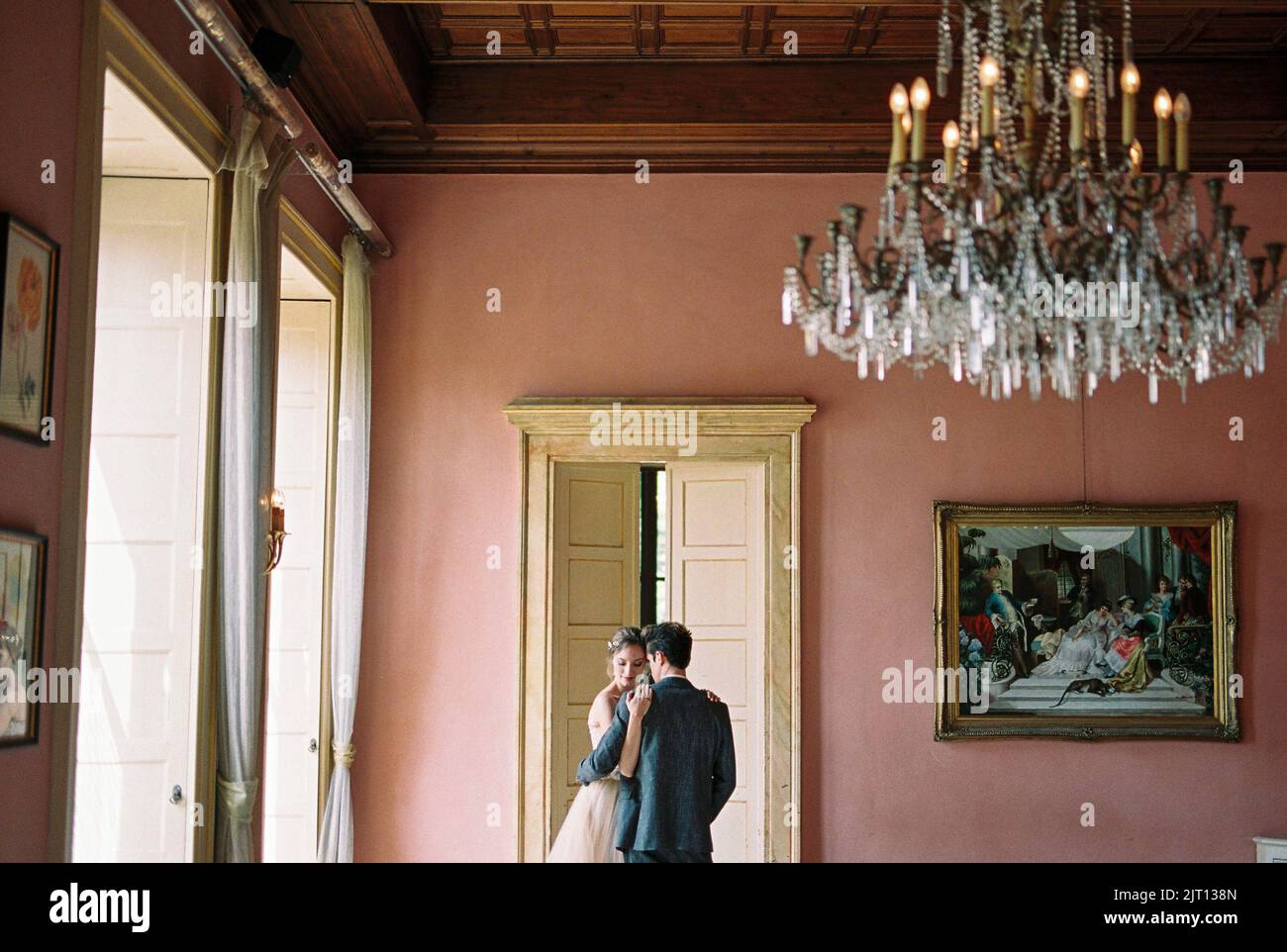 Bride and groom are standing near the door in an old villa. Lake Como ...