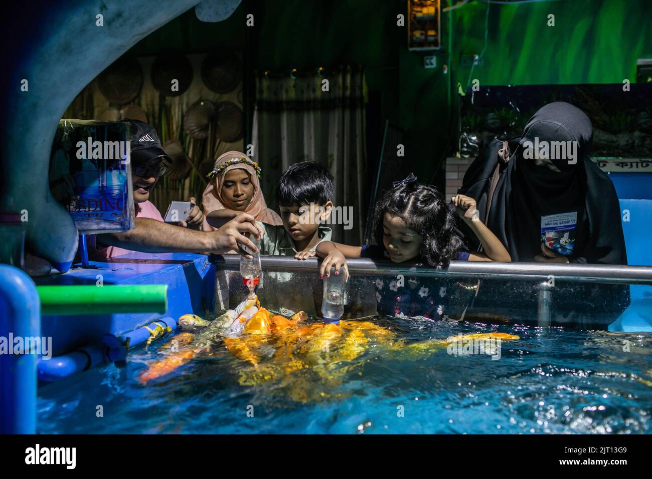 Dhaka, Bangladesh. 22nd Aug, 2022. Kids seen feeding fish in an