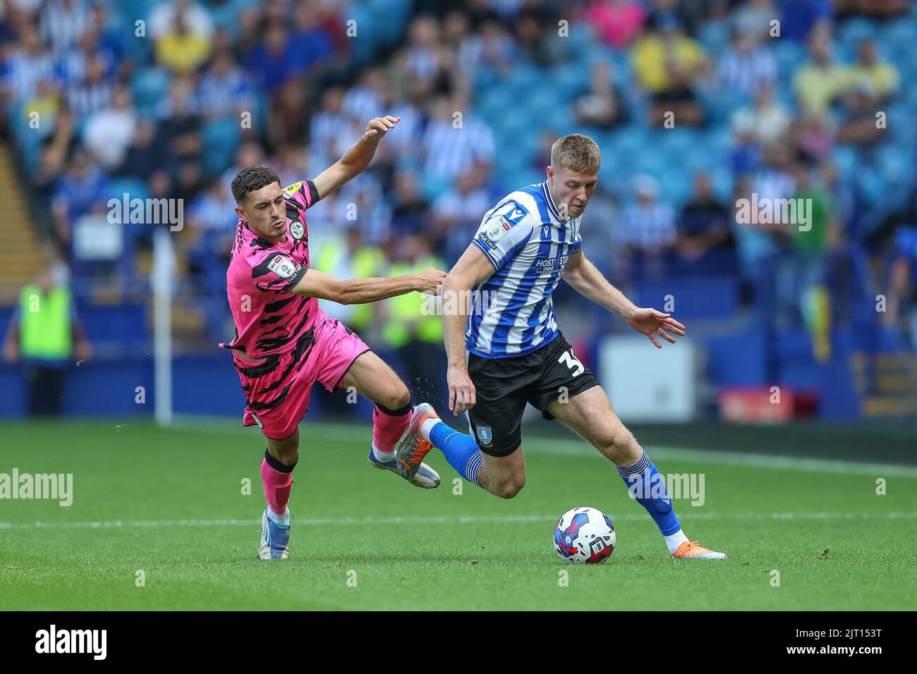 Mark McGuinness #34 of Sheffield Wednesday gets past Corey O'Keeffe #2 ...