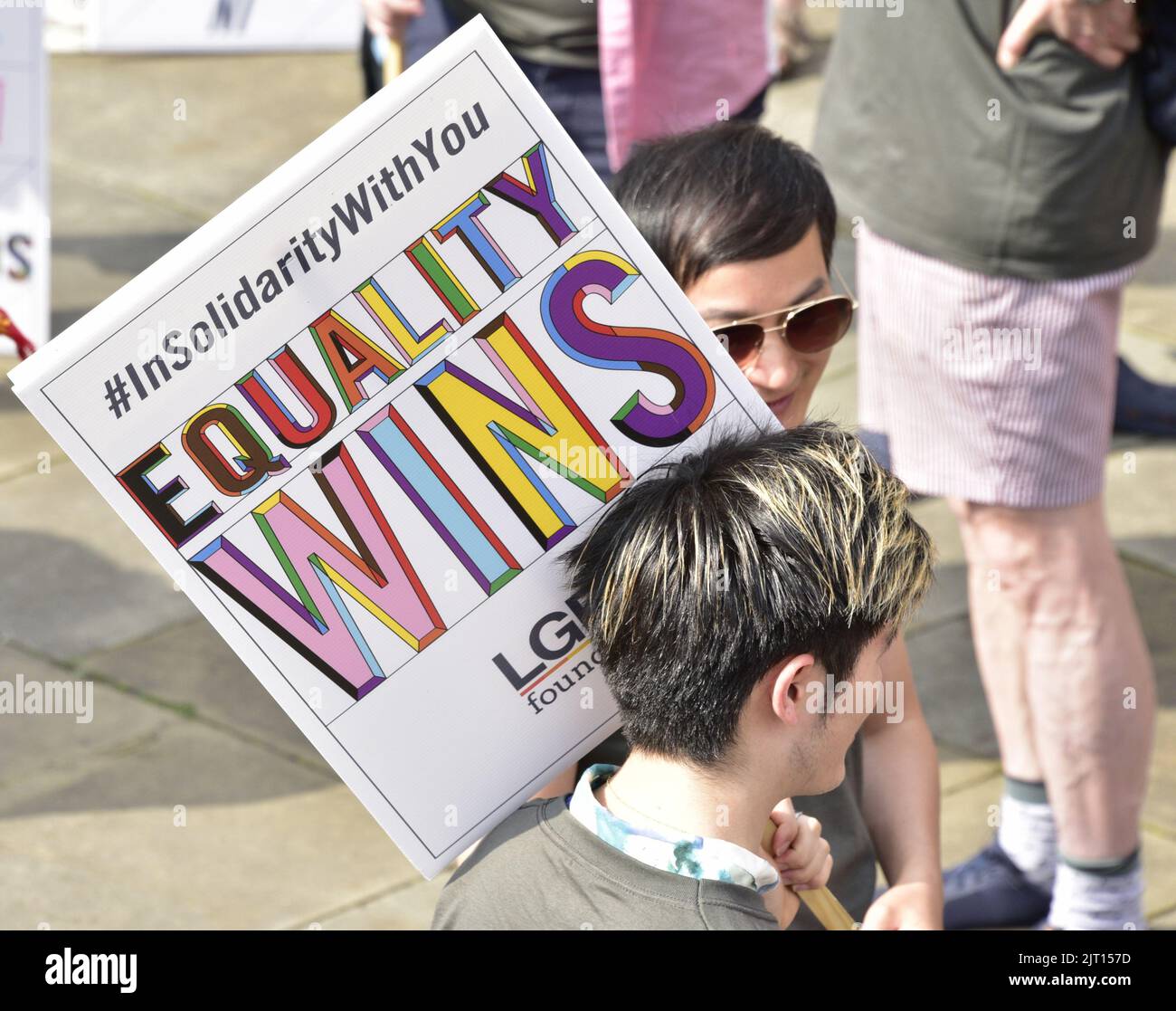 Manchester, UK. 27th August, 2022. A person carries an 'Equality Wins' placard. Participants get ready to take part in the LGBTQ+ Pride parade, central Manchester, UK, as LGBTQ+ Pride continues over the Bank Holiday weekend 26th to 29th August. Organisers say: 'Manchester Pride is one of the UK's leading LGBTQ+ charities. Our vision is a world where LGBTQ+ people are free to live and love without prejudice. We’re part of a global Pride movement celebrating LGBTQ+ equality and challenging discrimination.' Credit: Terry Waller/Alamy Live News Stock Photo