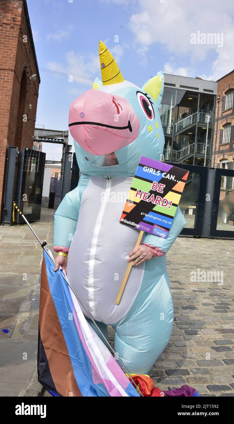 Manchester, UK. 27th August, 2022. A person in a unicorn inflatable with a girl guides group. Participants get ready to take part in the LGBTQ+ Pride parade, central Manchester, UK, as LGBTQ+ Pride continues over the Bank Holiday weekend 26th to 29th August. Organisers say: 'Manchester Pride is one of the UK's leading LGBTQ+ charities. Our vision is a world where LGBTQ+ people are free to live and love without prejudice. We’re part of a global Pride movement celebrating LGBTQ+ equality and challenging discrimination.' Credit: Terry Waller/Alamy Live News Stock Photo