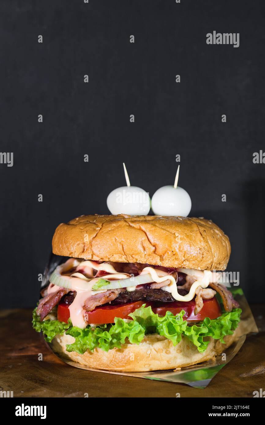 colombian hamburger served on a wooden board with a black background with space to copy text. street food in colombia made with two quail eggs in the Stock Photo