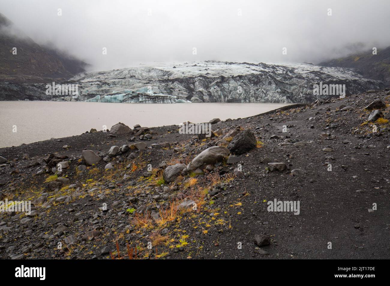 frontal view of Solheimajokull glacier tongue, Myrdalsjökull galcier, in Iceland on a rainy misty wet day at dusk, August 2020 Stock Photo