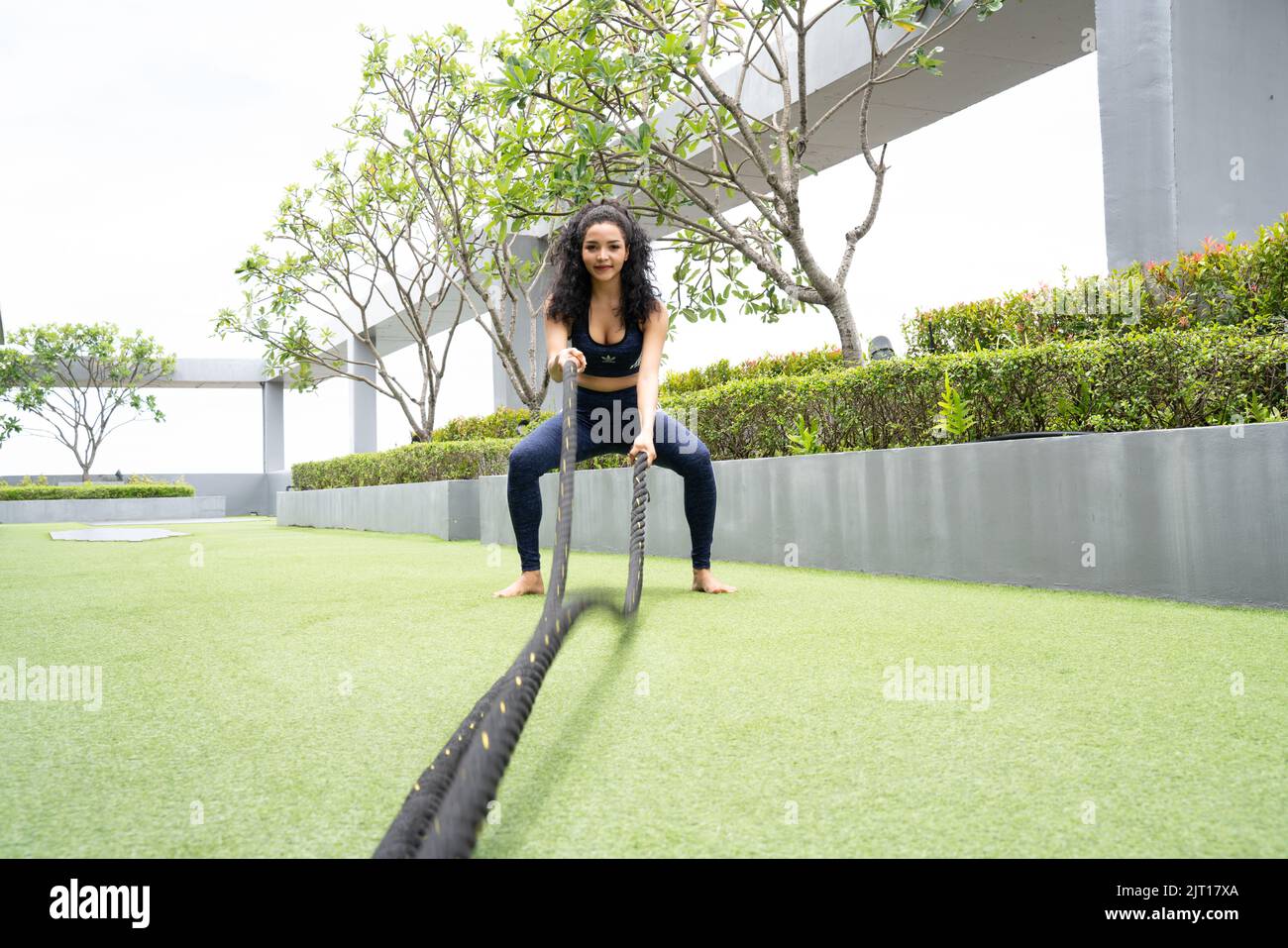 Woman doing Battle rope workout on roof top Condominium Stock Photo