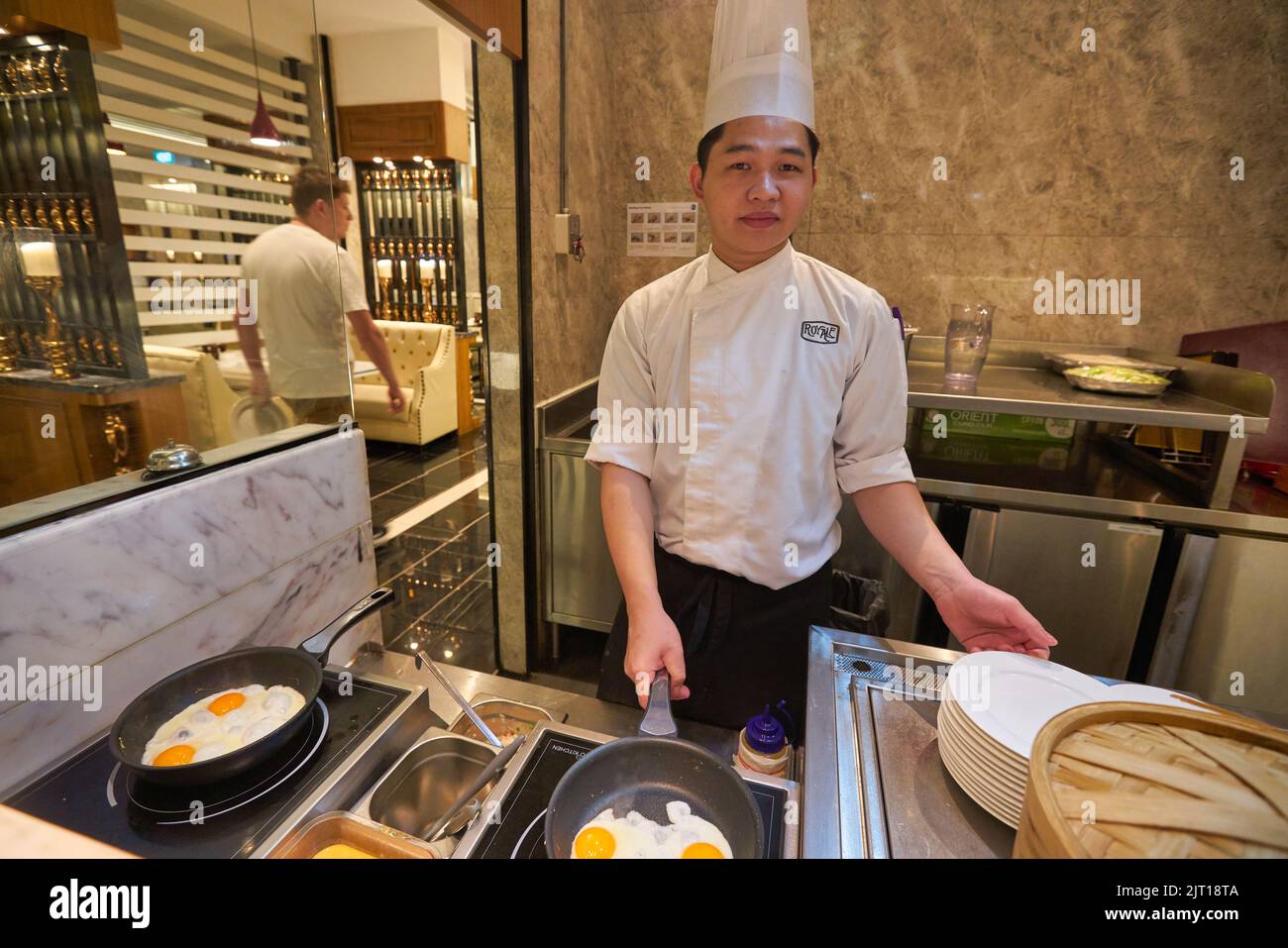SINGAPORE - CIRCA JANUARY, 2020: man cooking fried eggs at Mercure Singapore Bugis Stock Photo
