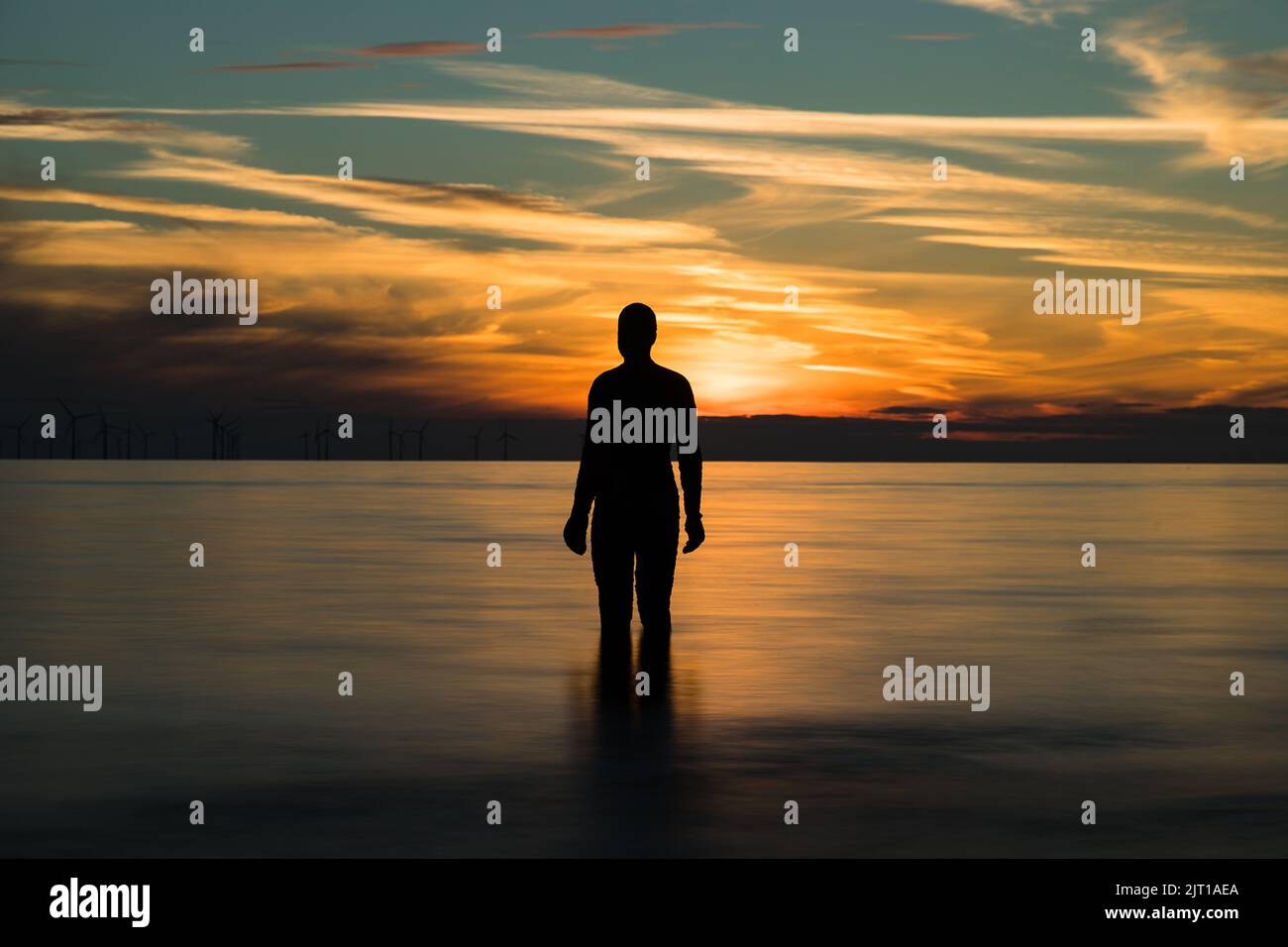 Sunset with an Iron Man seen on Crosby beach near Liverpool, taken 22nd Aug 2022. Stock Photo