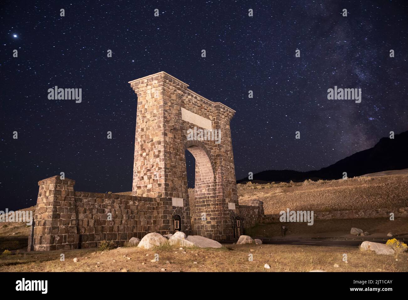 WY04992-00.....WYOMING - Roosevelt Arch at night. The archway marks the North Entrance to  Yellowstone National Park. Stock Photo