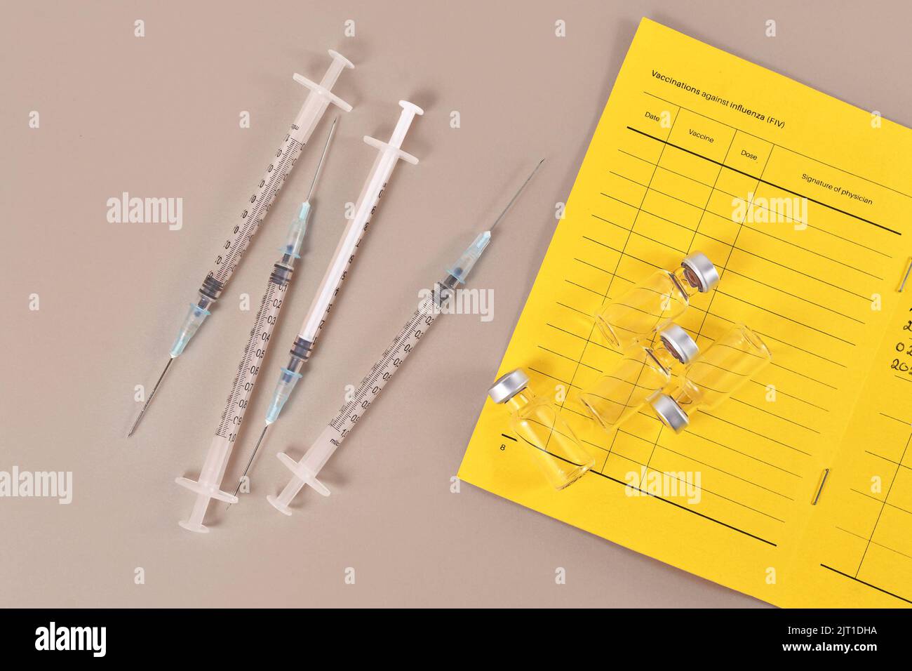 Concept for Corona virus booster vaccination showing vaccine passport with 4 syringes and vials Stock Photo