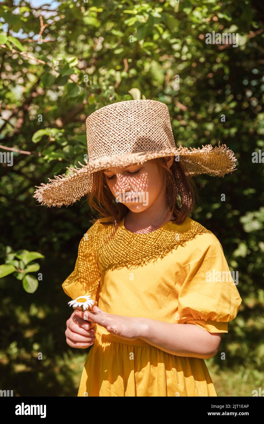 cute little girl in a yellow dress and straw hat walking Stock Photo ...