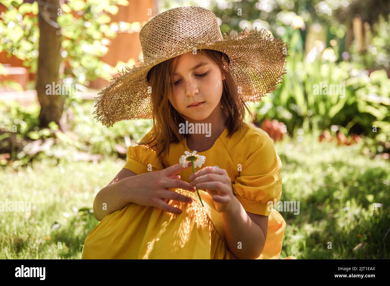 cute little girl in a yellow dress and straw hat walking Stock Photo ...